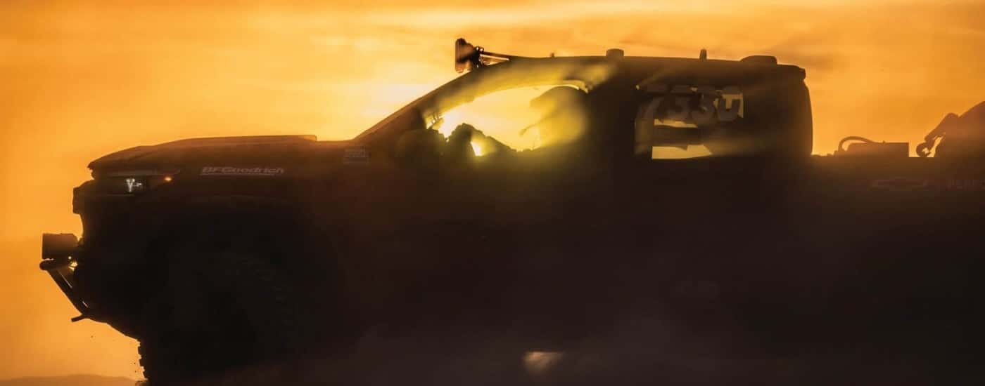 Silhouette of a 2023 Chevy Colorado ZR2 off-roading at dusk