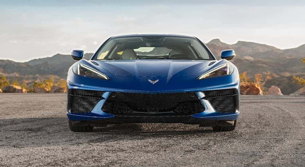A blue 2022 Chevy Corvette Stingray is shown from the front parked in a remote location.