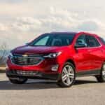 A red 2019 used Chevy Equinox is parked at a lookout with a view.