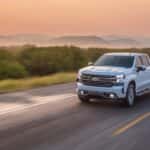 A white 2020 used Chevy Silverado 1500 is shown driving on an open road.