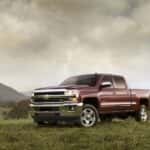 A maroon 2015 used Chevy Silverado 2500 HD Z71 is shown parked on a field.