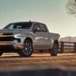 A silver 2022 Chevy Silverado 1500 Z71 is shown parked in front of a fence.