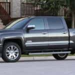 A grey 2014 Chevy Silverado 1500 High Country is shown parked on the side of a city street.