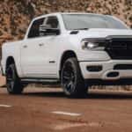 A white 2022 Ram 1500 is shown from the front at an angle after leaving a dealer that has used trucks for sale near Rayford.