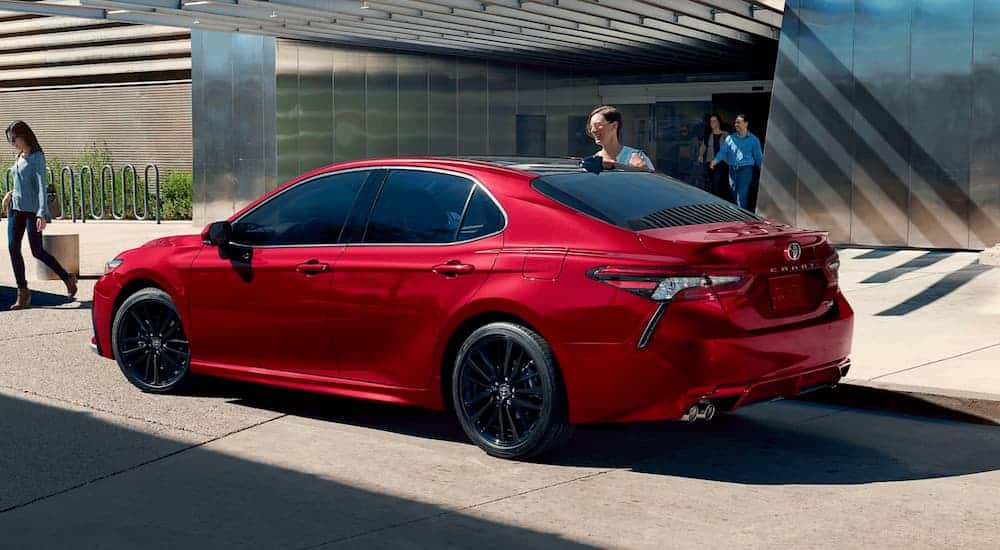 Red 2021 Toyota Camry with a family piling in