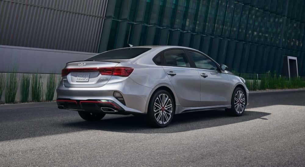 Silver 2023 Kia Forte GT driving to see used cars for sale near Cypress