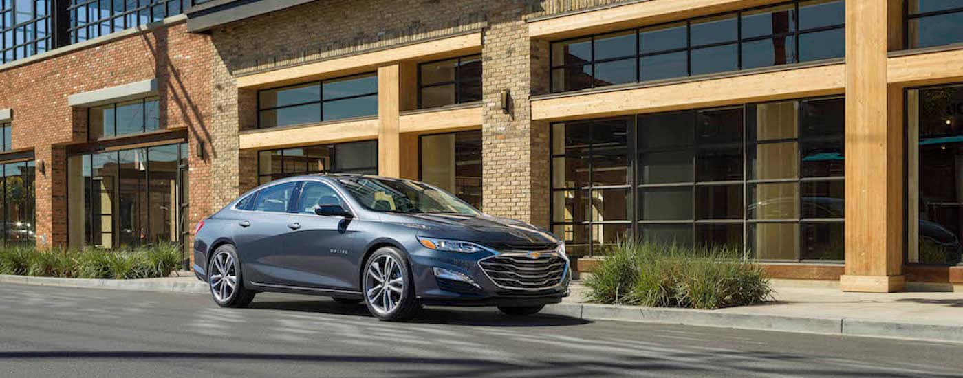 A grey 2021 Chevy Malibu from the front at an angle after leaving a dealer with used cars for sale near Cypress.