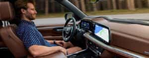 A person driving in a 2025 Chevy Suburban for sale.