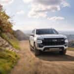 A white 2021 Chevy Tahoe driving on a dirt road.