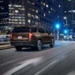 A brown 2021 Chevy Tahoe for sale near Houston is driving in a city.