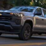 A silver 2026 Chevy Colorado for sale in Tomball driving on a highway.