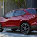 A red 2024 Chevy Equinox parked near used SUVs for sale near Houston.