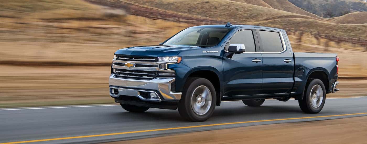 Blue 2021 Chevy Silverado 1500 driving up a mountain road