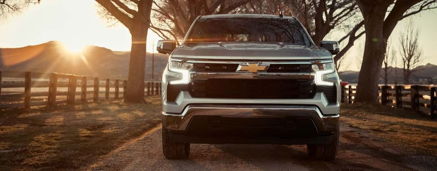 A silver 2023 Chevy Silverado 1500 driving down the driveway of a ranch