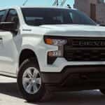 A white 2026 Chevrolet Silverado 1500 WT parked near a building.