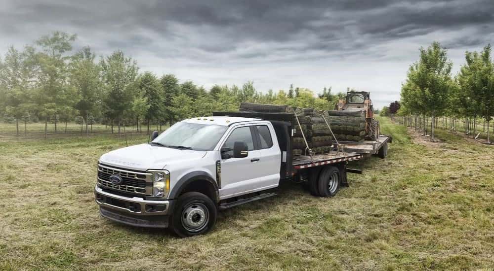 A white 2023 Ford F-450 towing a trailer.
