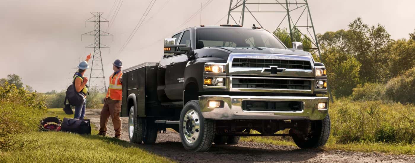 Black 2026 Chevy Silverado 5500 HD parked near power lines with workers