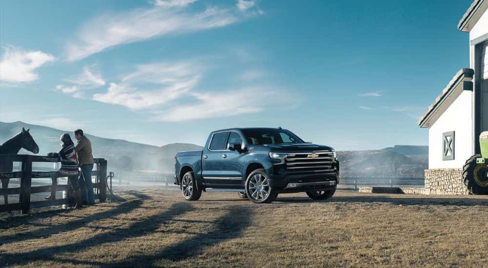 A blue 2023 Chevy Silverado 1500 driving in the country.
