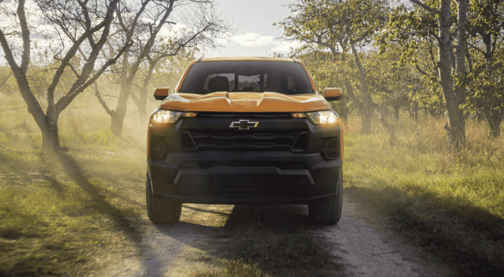 Orange 2026 Chevy Colorado driving down a trail