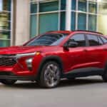 A red 2026 Chevy Trax 2RS parked in front of a building.