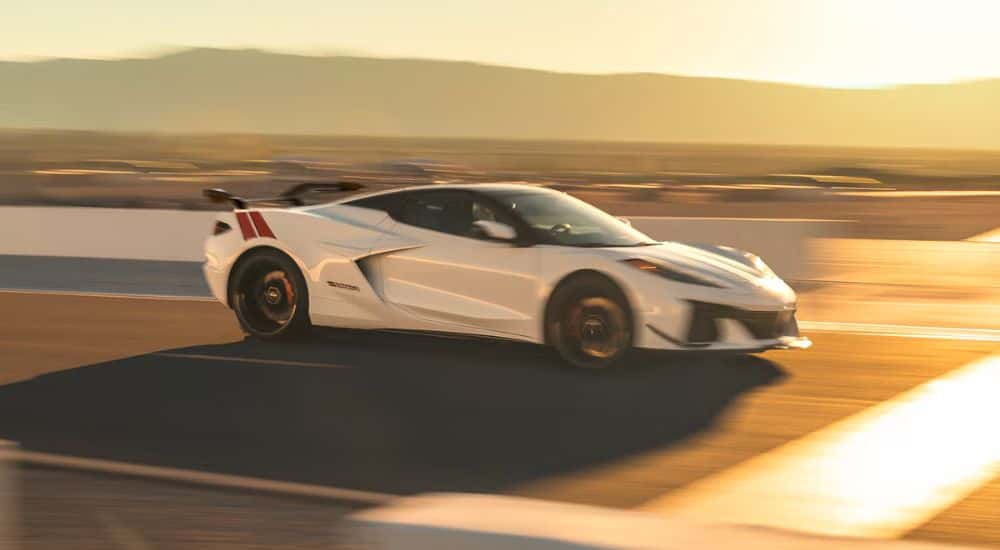 White 2027 Chevy Corvette Grand Sport speeding on a racetrack.