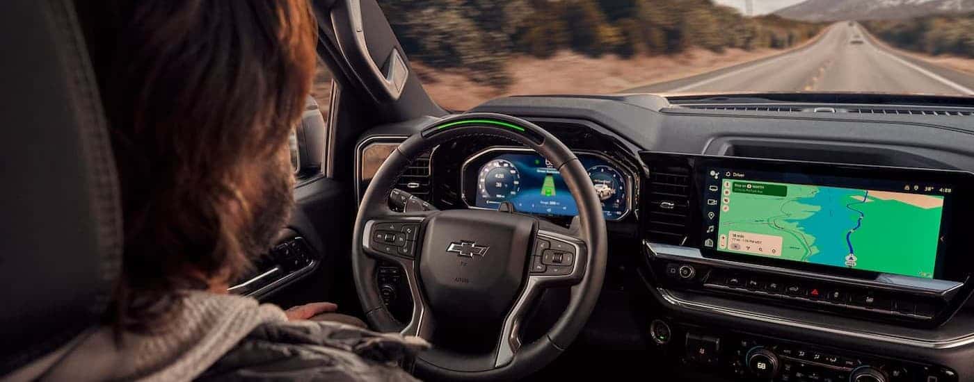 A person driving in a 2026 Chevy Silverado 1500.