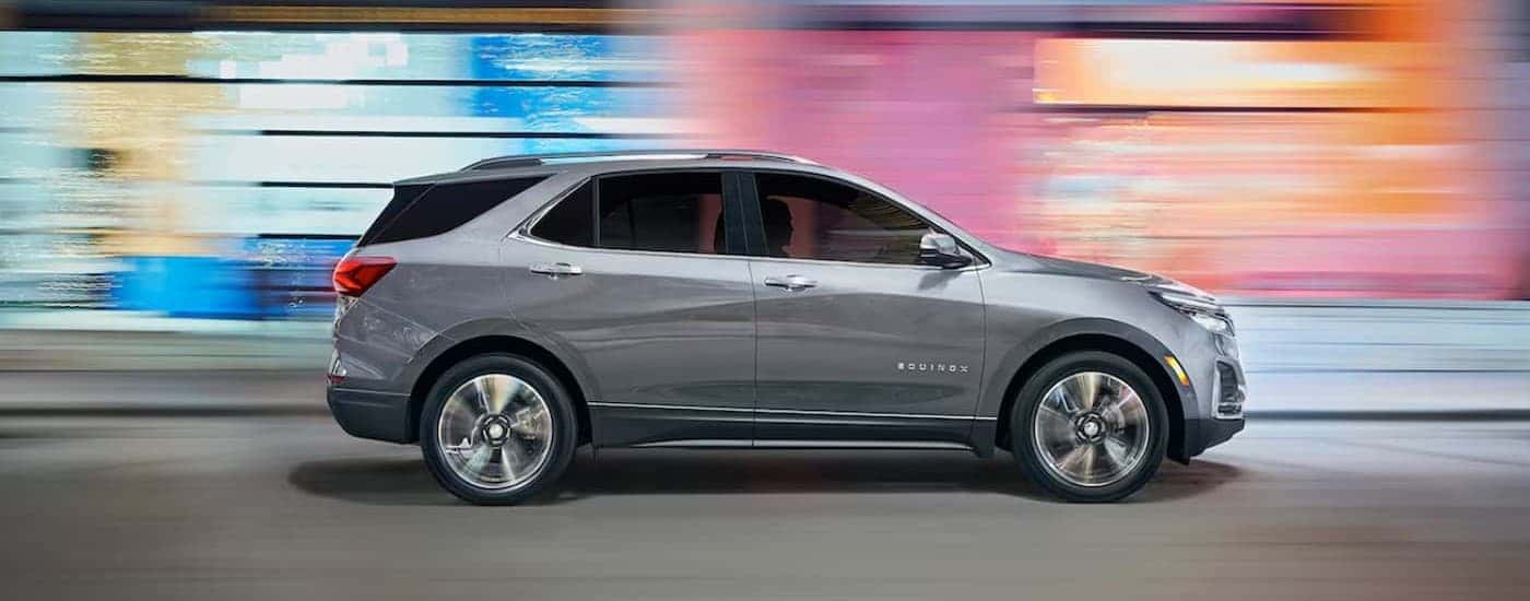 A silver 2024 Chevy Equinox driving in a city.