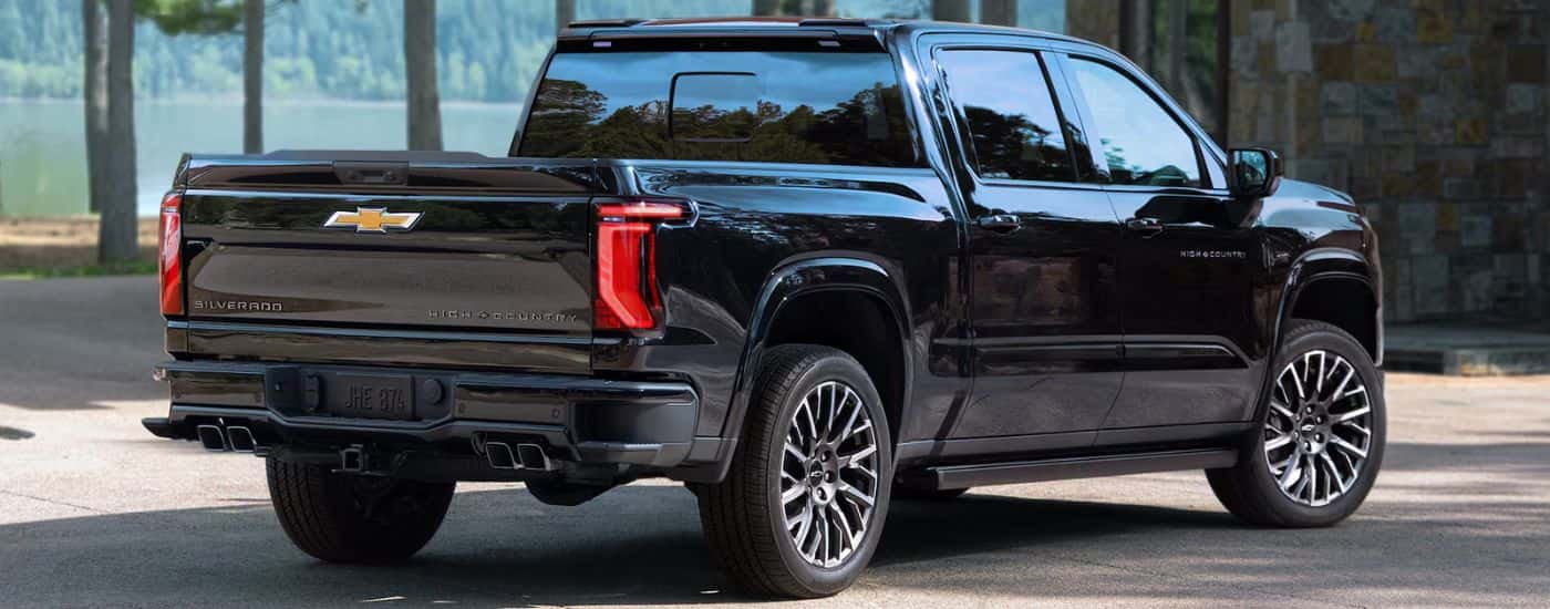A black 2027 Silverado 1500 High Country by a lake.