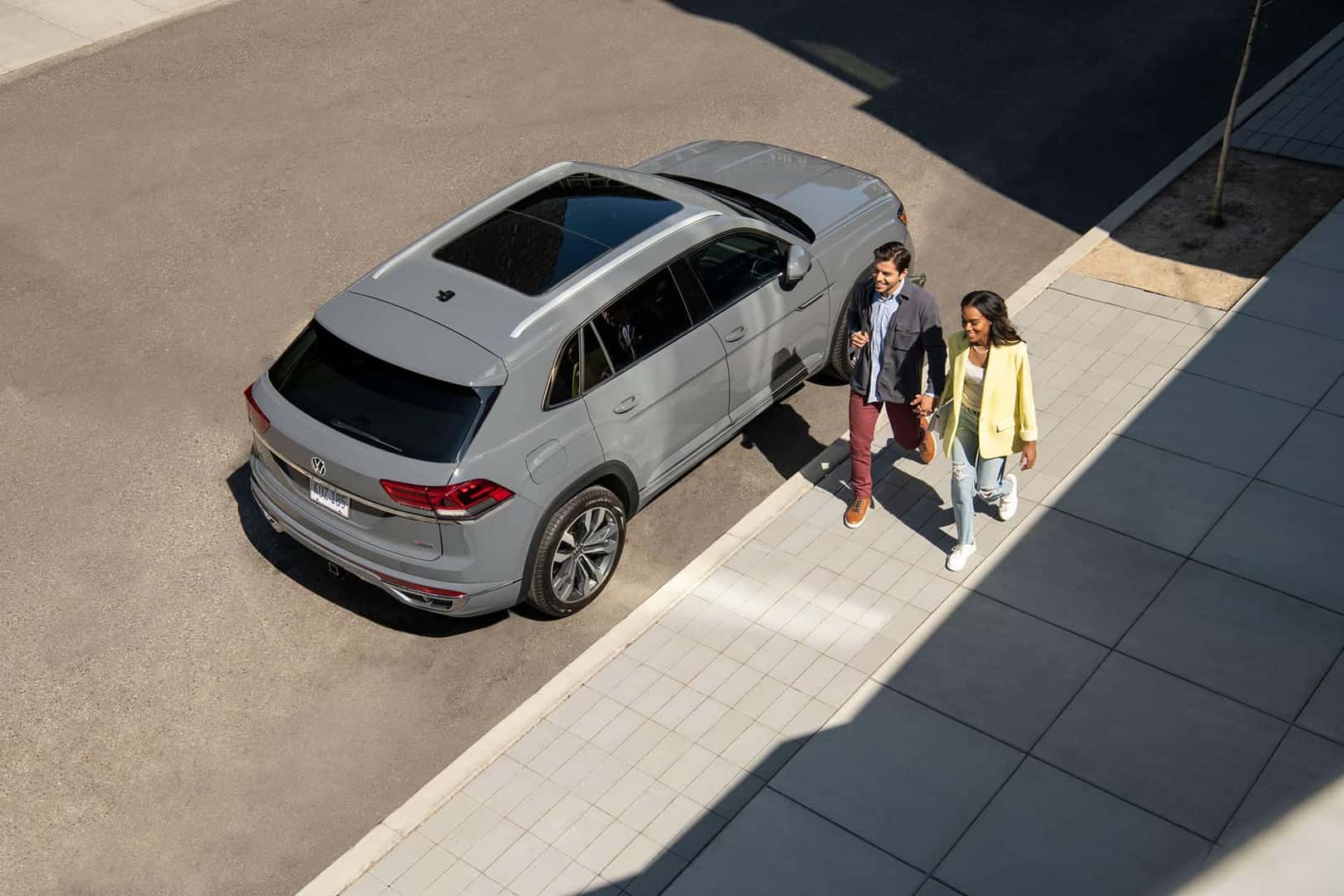 couple walking next to 2026 volkswagen atlas cross sport