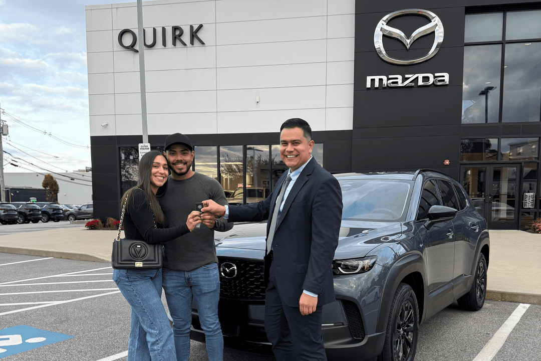 Quirk sales team handing keys to happy customers