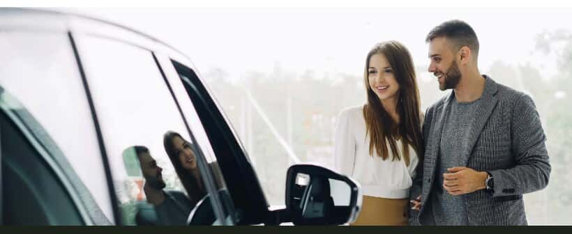 A couple beside a new car