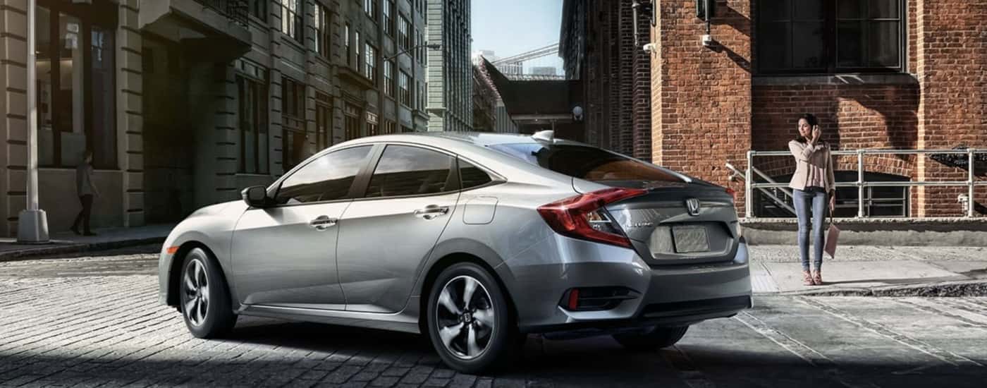 Silver 2016 Honda Civic Touring driving to a used Honda dealer