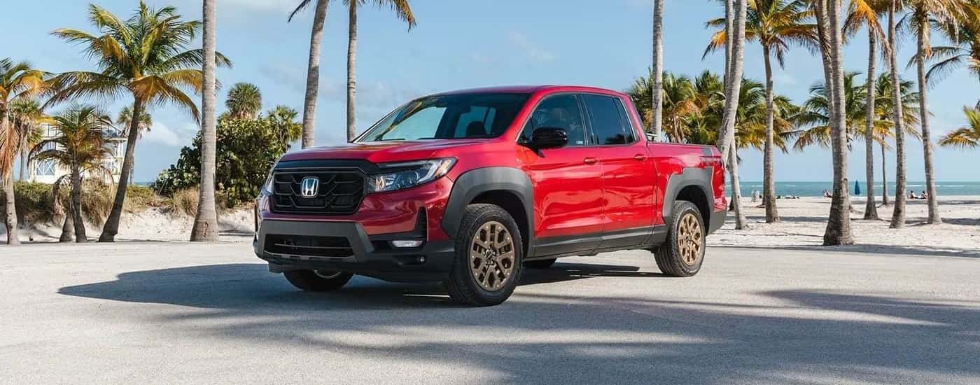 Red 2023 Honda Ridgeline HPD parked on sand