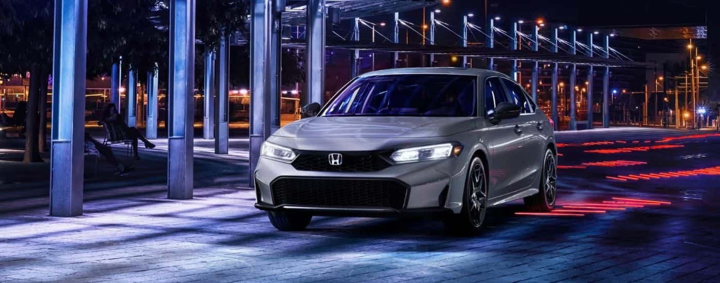 Silver 2026 Honda Civic Sport driving at night