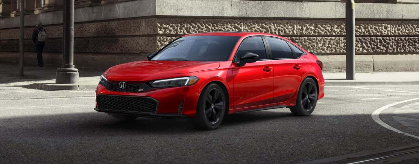 Red 2025 Honda Civic Si driving around a bend from a Honda dealer near Parrish.