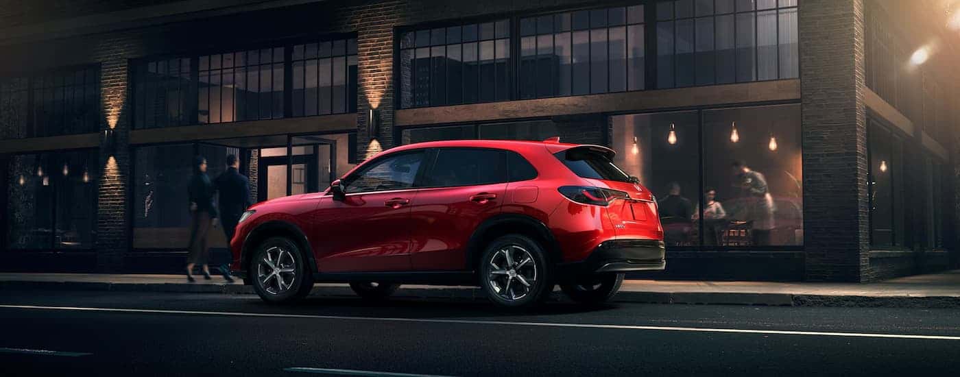 Side of a red 2025 Honda HR-V parked beside a curb.