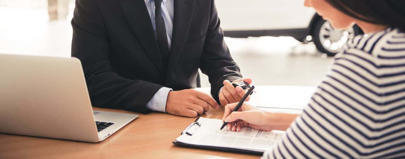A customer is shown completing financing with a manager.