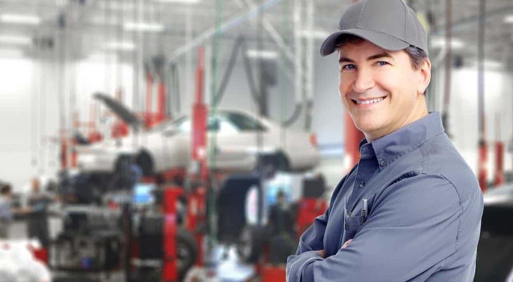 A mechanic smiling in a garage.