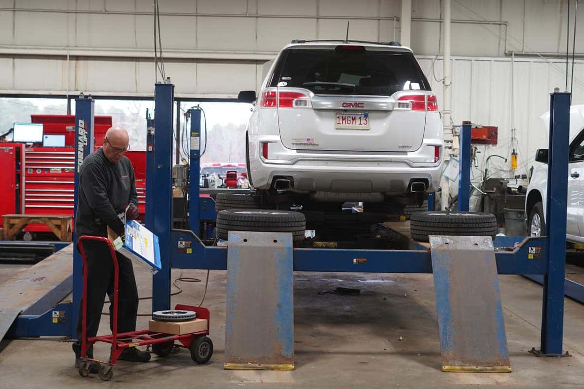 mechanic with vehicle on lift