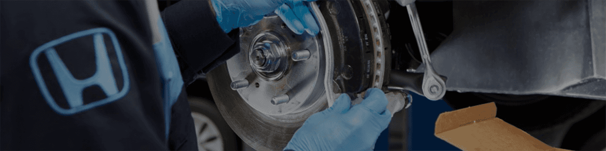 Honda-Technician-doing-an-oil-change-underneath-a-vehicle