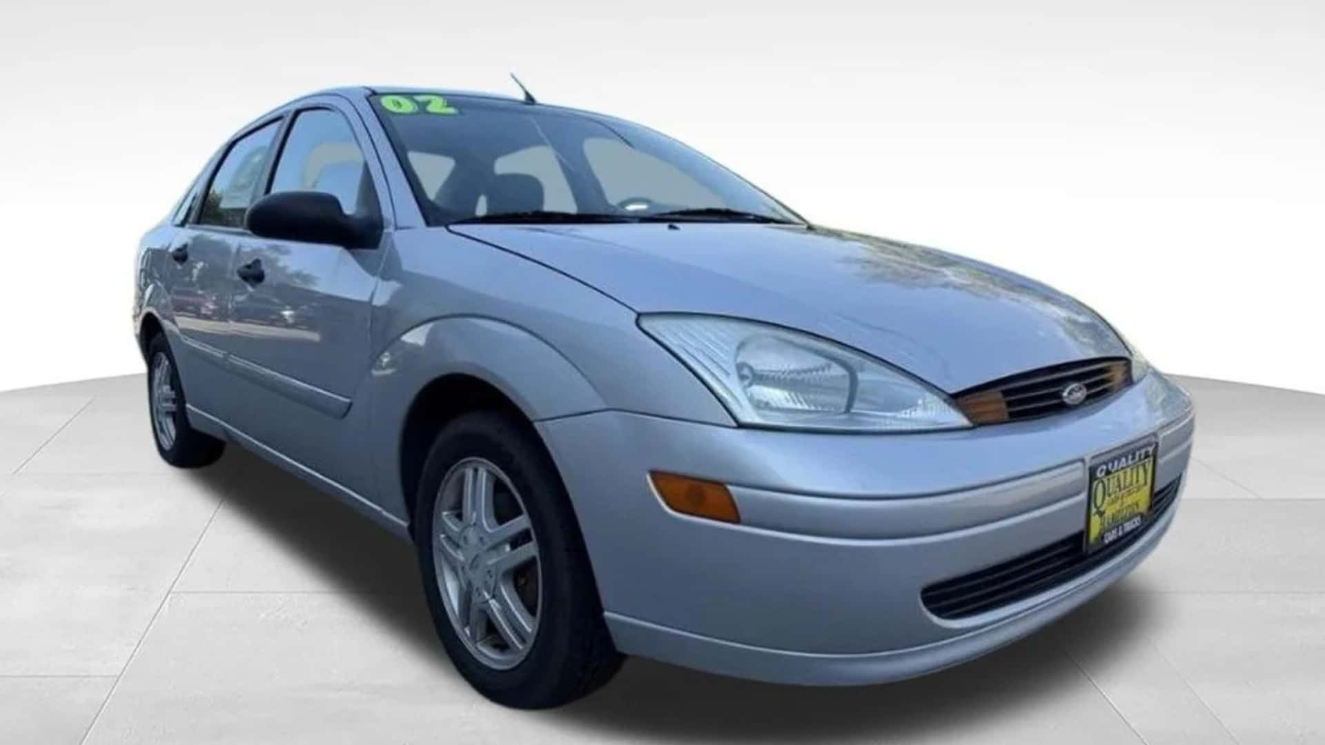 Silver Ford Focus sedan front three-quarter view with compact body design, alloy wheels, and dealer plate.