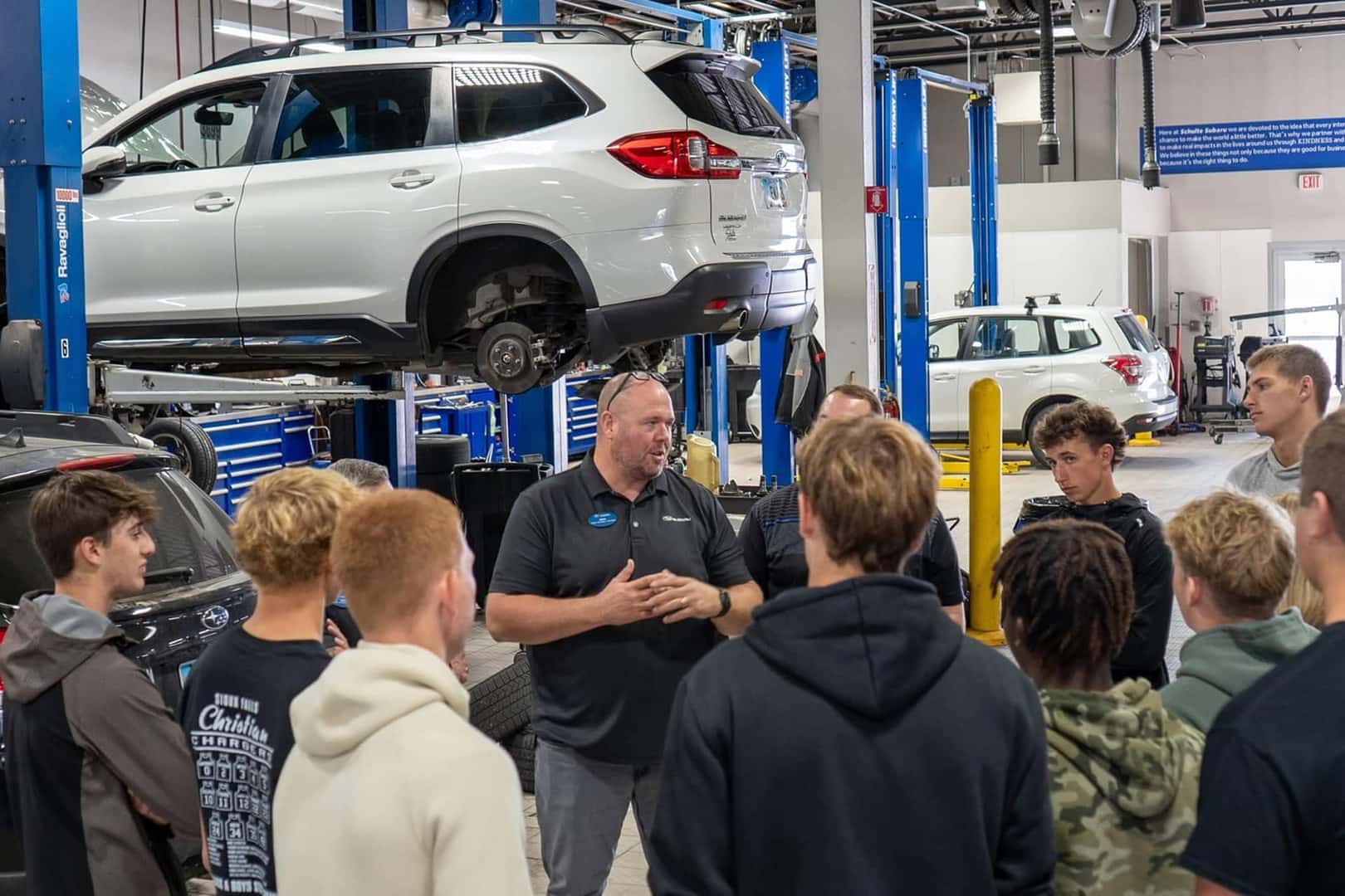 service technician talking to young kids in dealership service center