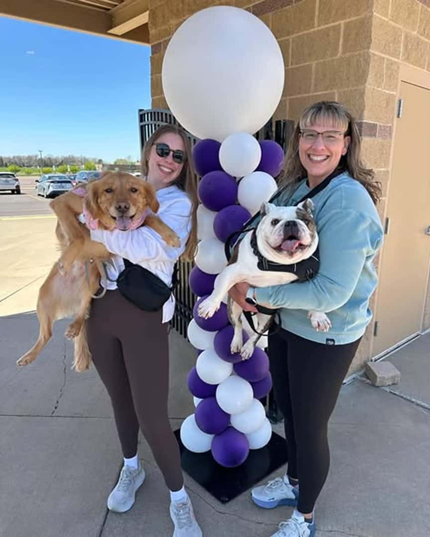 two women holding dogs