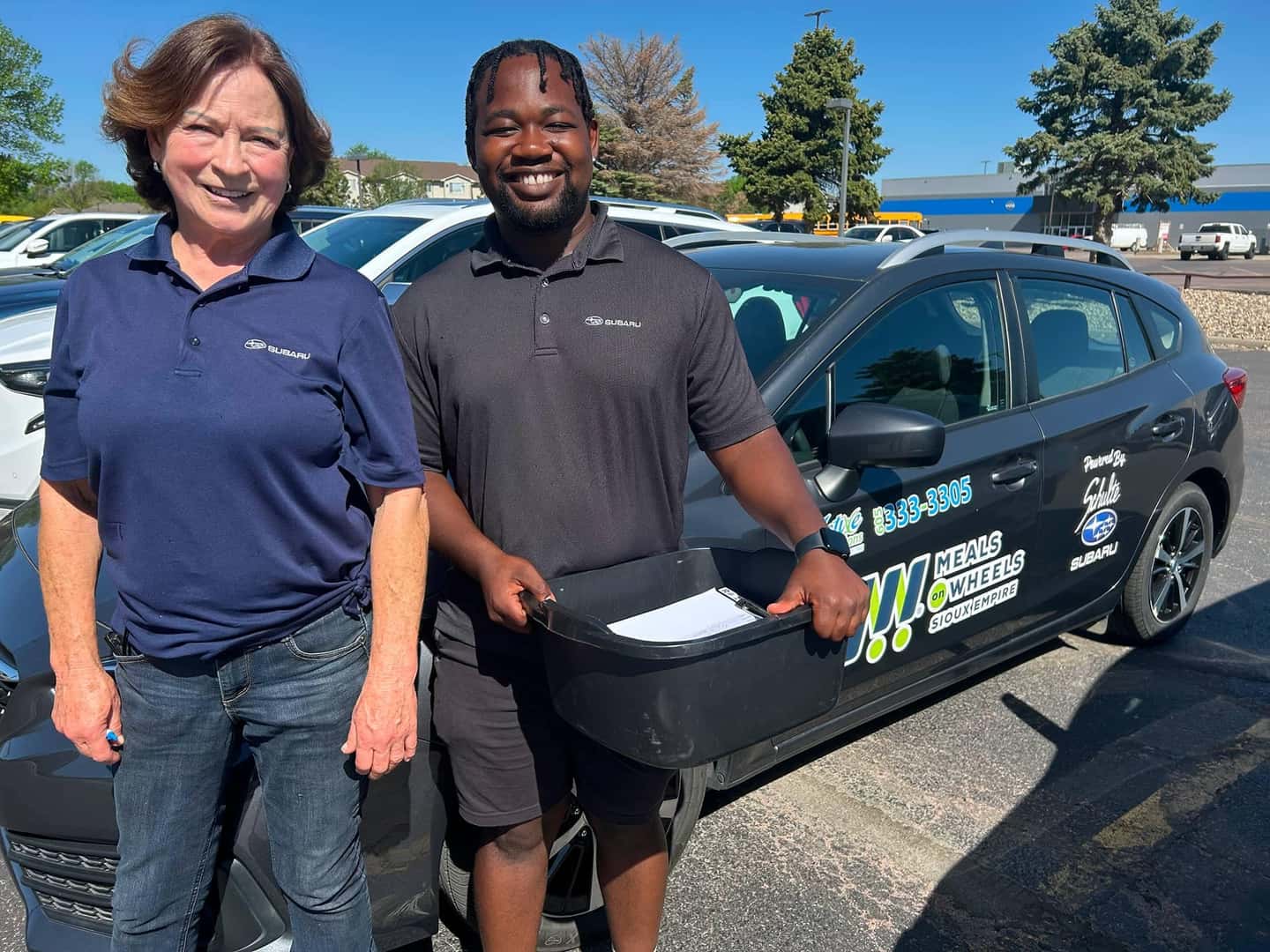 two people standing next to car
