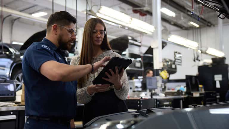 Associate overviewing details on a vehicle with another associate