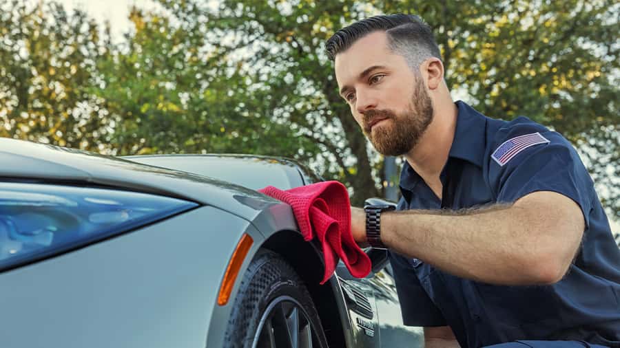 Sewell car wash associate putting extra detail on the front of a vehicle.