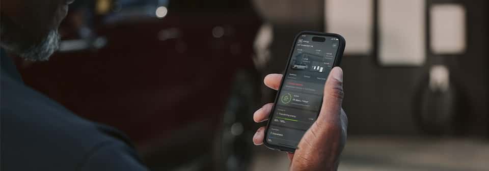 Customer reviewing details on Cadillac vehicle on their phone.