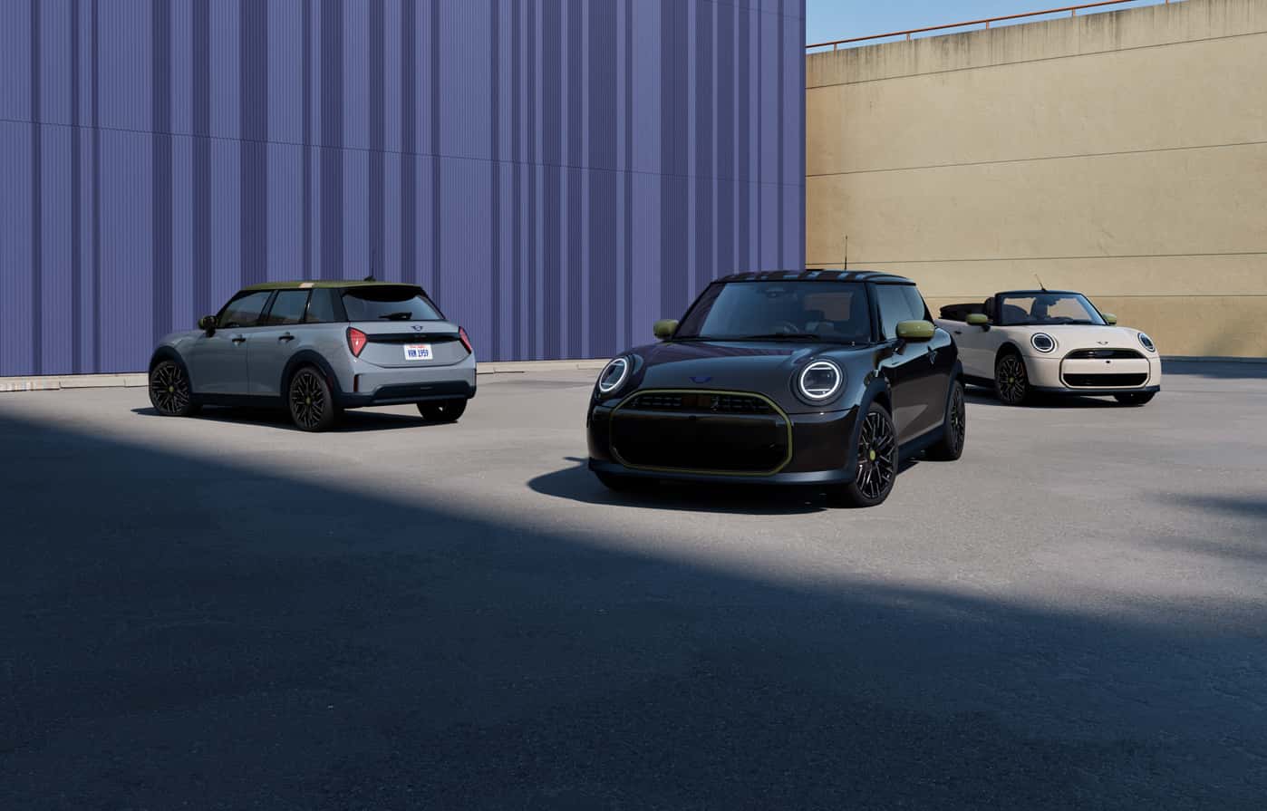 Three MINI vehicles parked in an open urban setting.