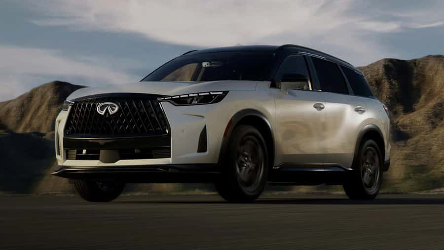 INFINITI QX60 luxury SUV driving through an open scenic landscape.