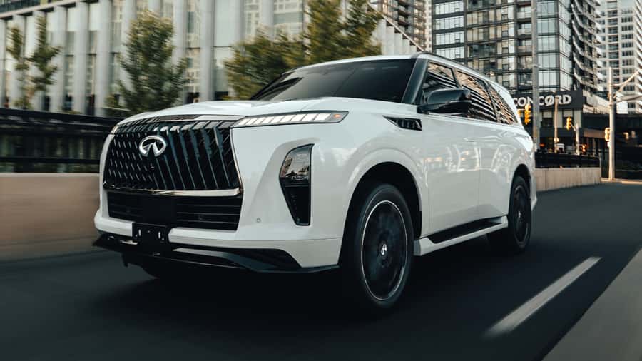 INFINITI QX80 full size luxury SUV driving through an urban city street.